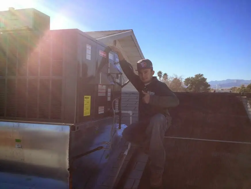 HVAC technician performing AC Tune-Up on a rooftop unit in Rincon Valley